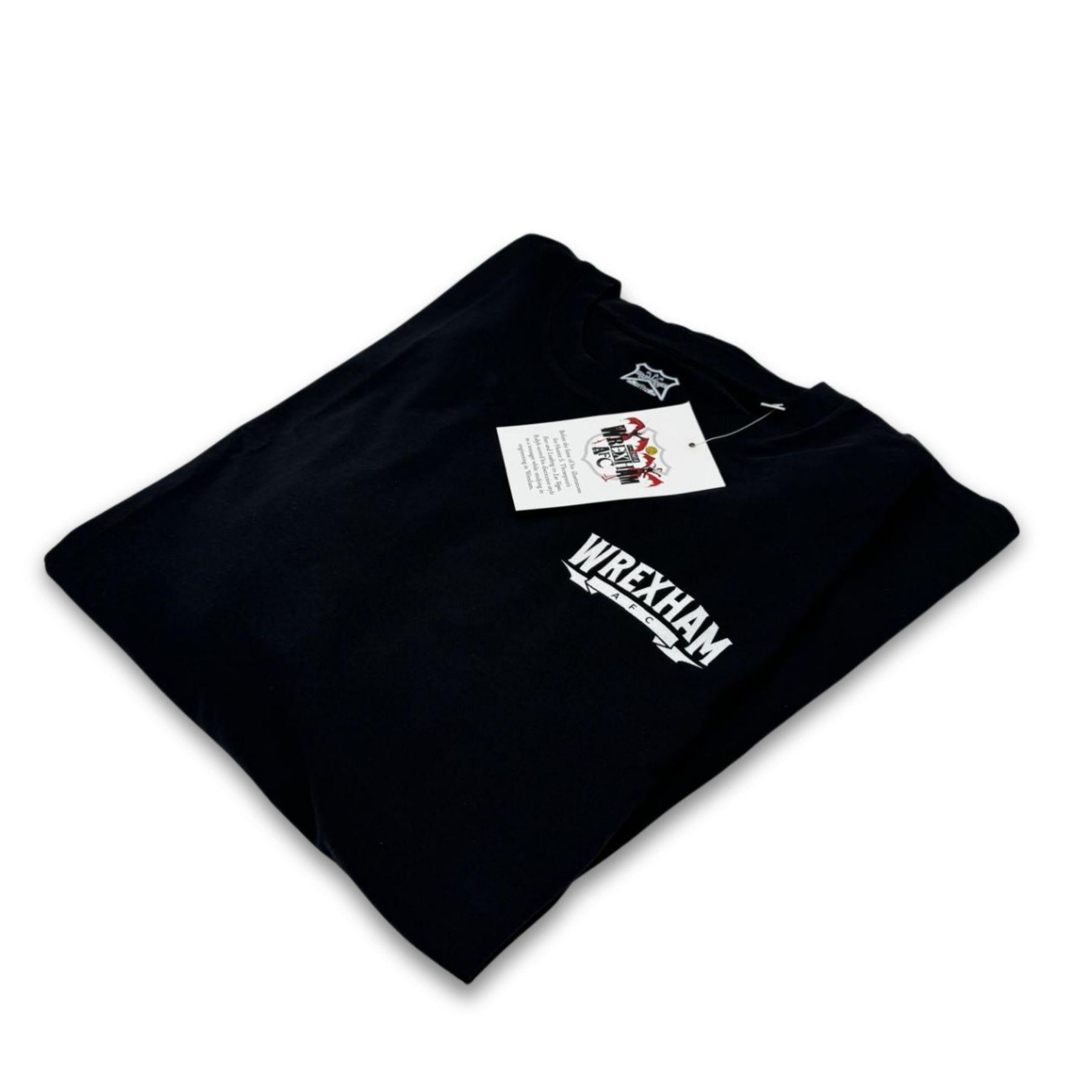 Folded black t-shirt with 'Wrexham' text on a white background
