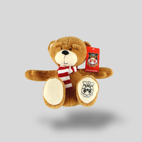 Plush teddy bear with a red tag on a gray background